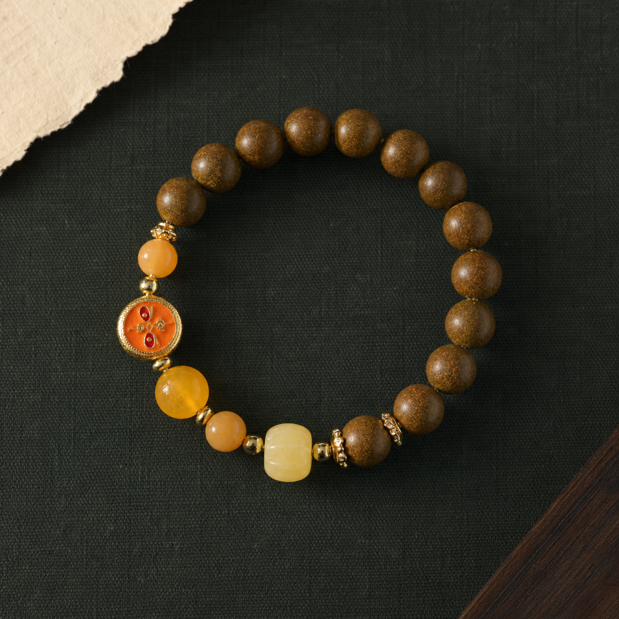 Brown He Xiang bracelet with warm yellow stone beads, an orange glass feature element and gold-toned spacers