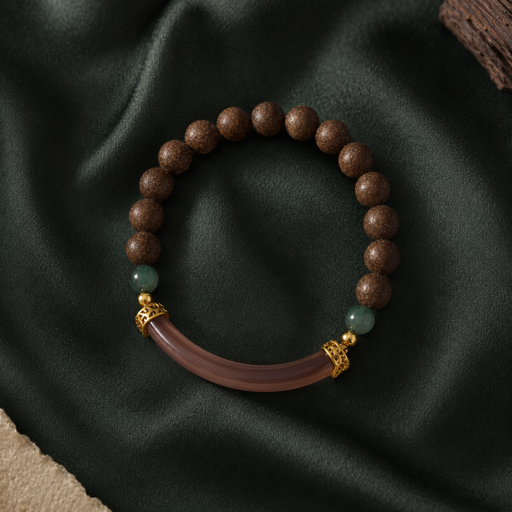 Brown He Xiang bracelet with green accent beads, gold-toned spacers and a curved translucent decorative component