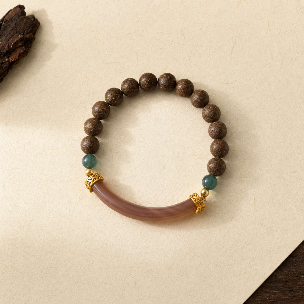 Brown He Xiang bracelet with green accent beads, gold-toned spacers and a curved translucent decorative component