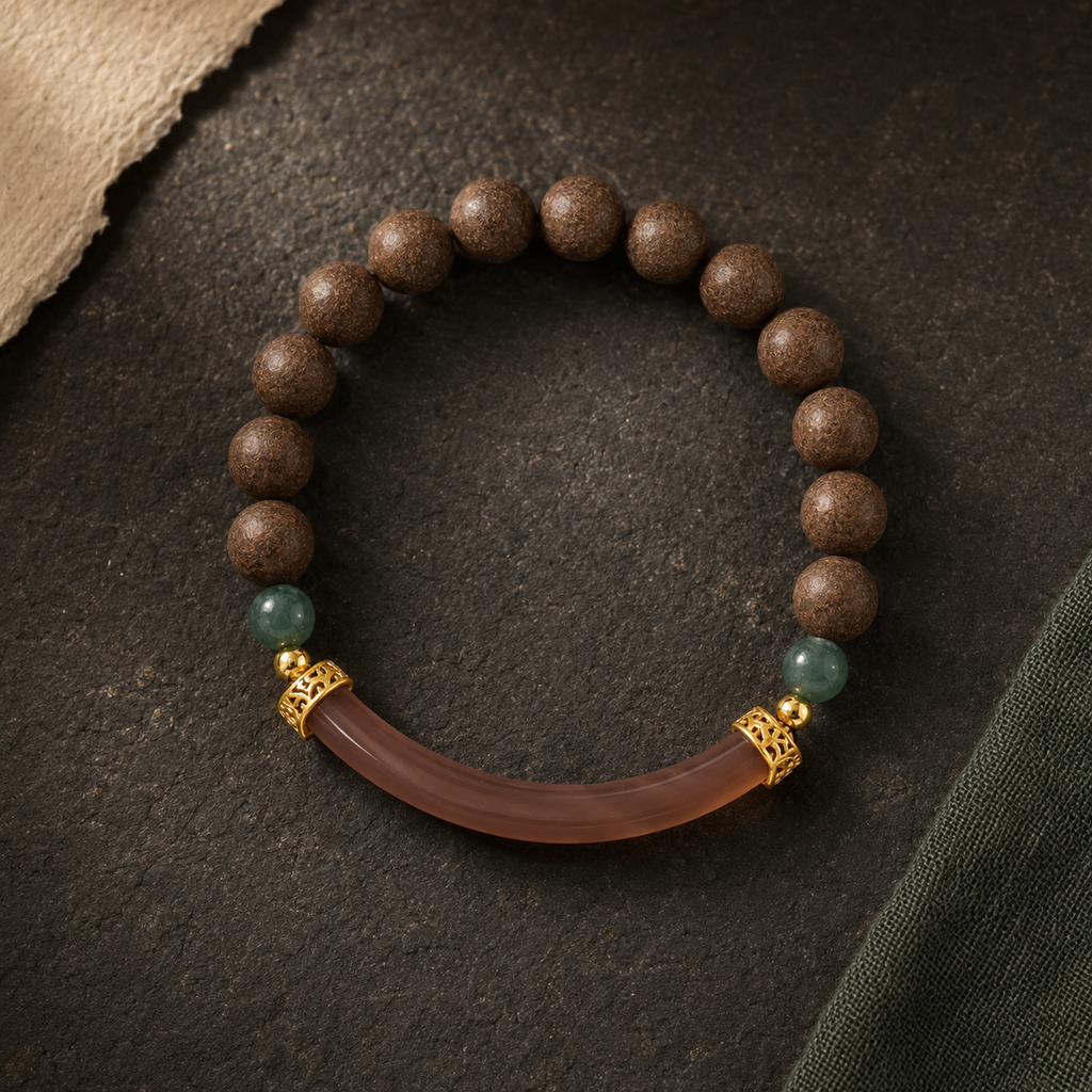 Brown He Xiang bracelet with green accent beads, gold-toned spacers and a curved translucent decorative component