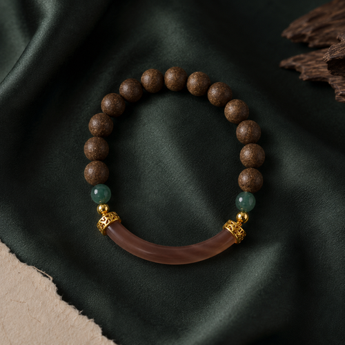 Brown He Xiang bracelet with green accent beads, gold-toned spacers and a curved translucent decorative component