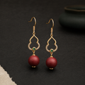 Deep rose He Xiang bead drop earring with a gold-toned openwork hook and a small green accent