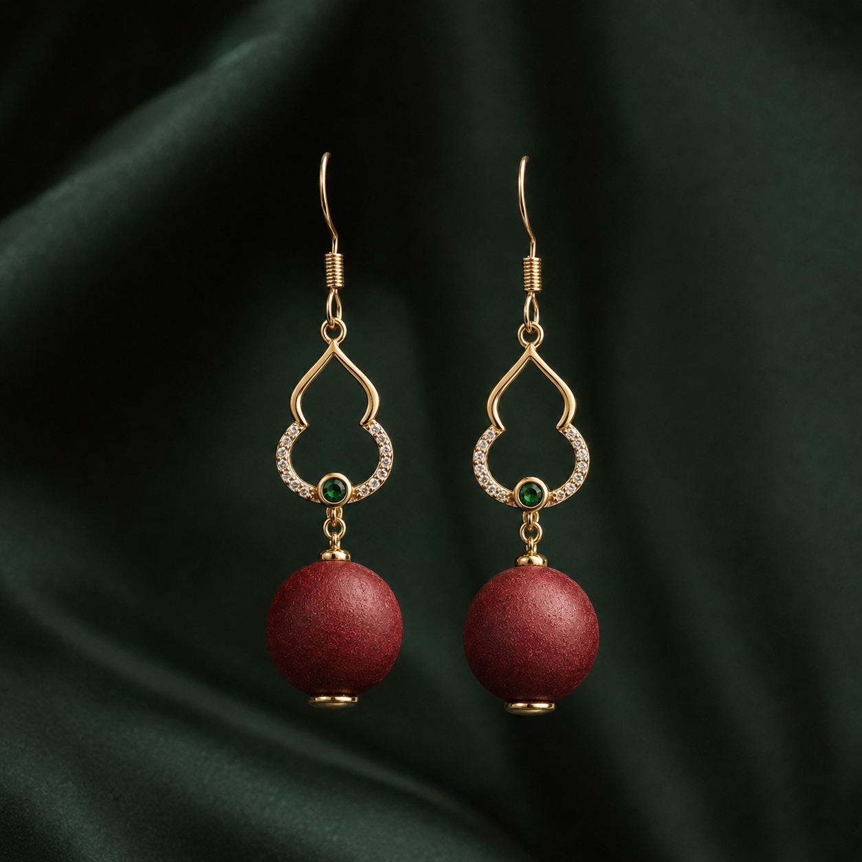 Deep rose He Xiang bead drop earring with a gold-toned openwork hook and a small green accent