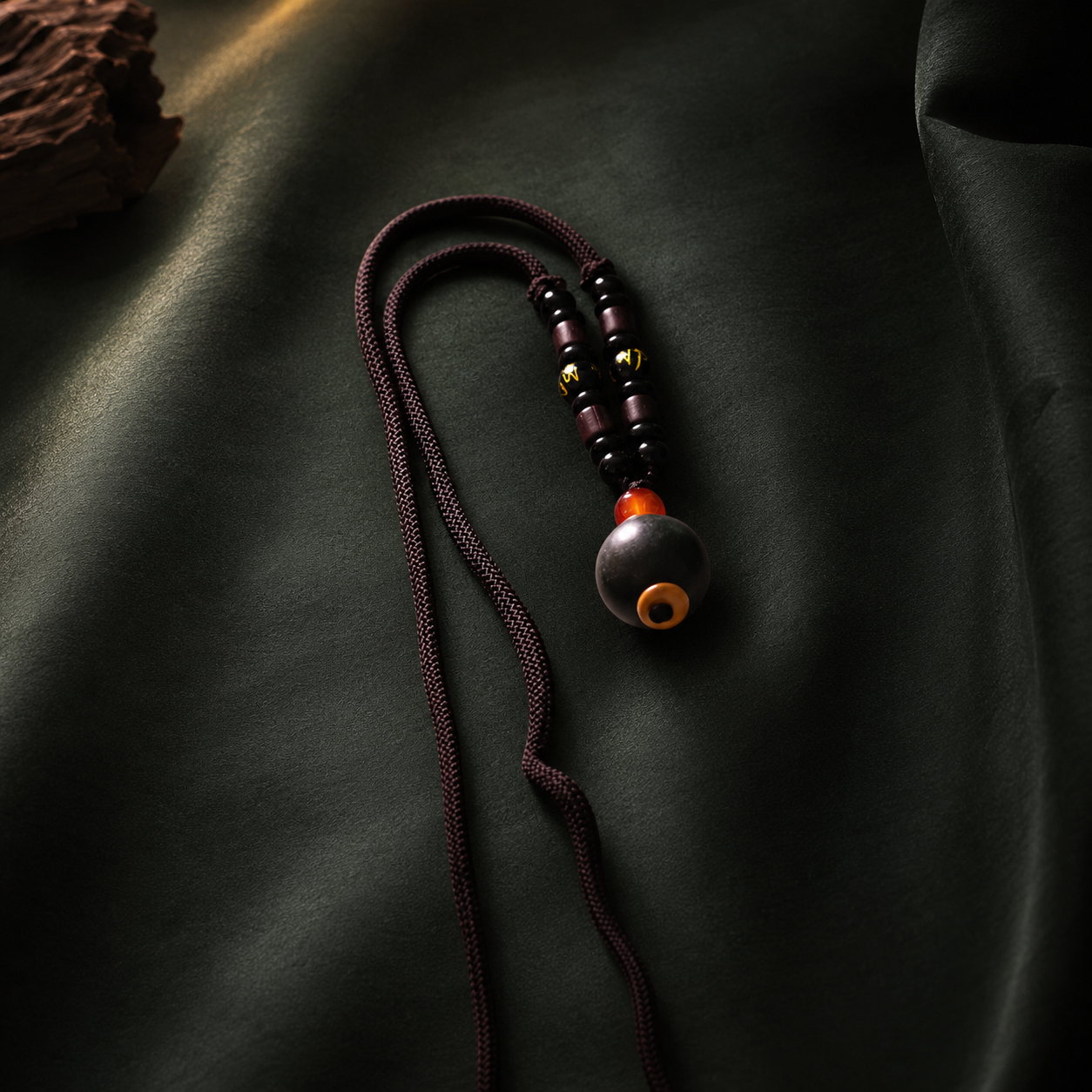 Dark braided He Xiang pendant necklace with a single aromatic bead, plum accents and an orange-red spacer