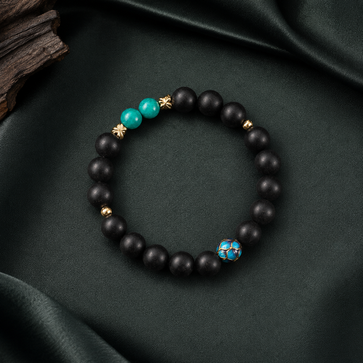Valley Orchid He Xiang bracelet with matte black aromatic beads, turquoise accents and a blue enamel feature bead