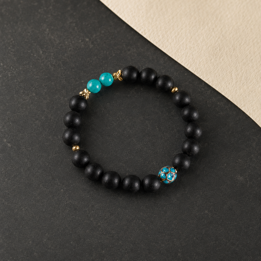 Valley Orchid He Xiang bracelet with matte black aromatic beads, turquoise accents and a blue enamel feature bead